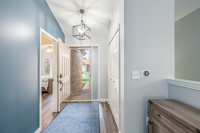 interior space featuring lofted ceiling, dark wood finished floors, and a chandelier