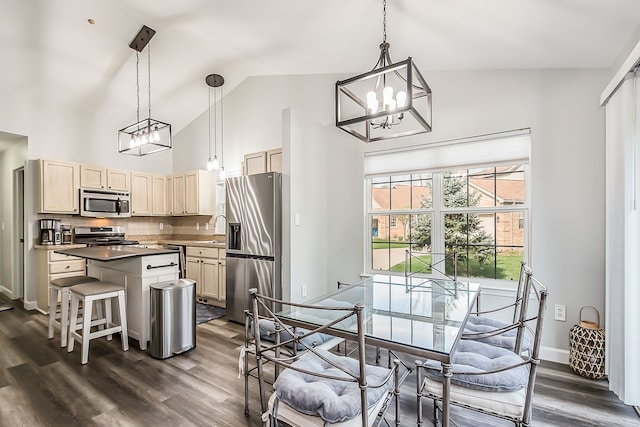 dining area featuring an inviting chandelier, dark wood finished floors, baseboards, and high vaulted ceiling