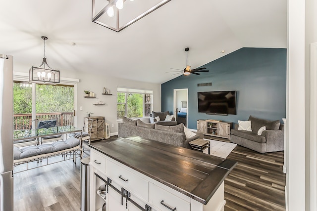 kitchen with white cabinets, open floor plan, dark wood finished floors, and lofted ceiling