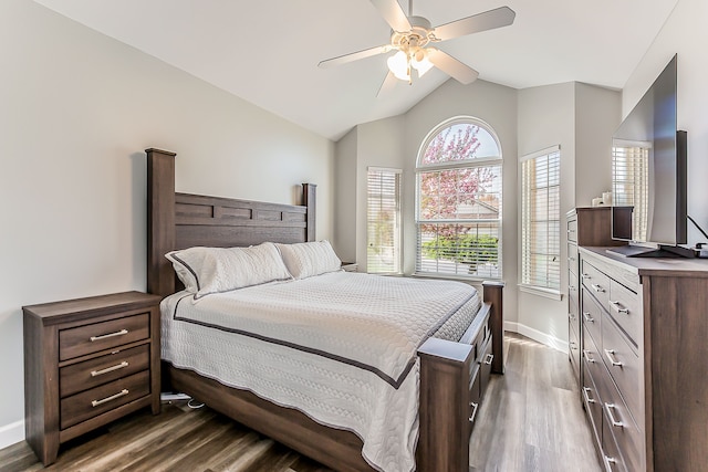 bedroom featuring a ceiling fan, baseboards, dark wood-style floors, and lofted ceiling