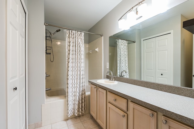 bathroom with tiled shower / bath combo, a closet, tile patterned flooring, and vanity