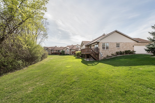 view of yard featuring a garage, a wooden deck, and stairway