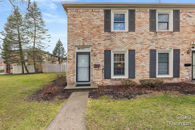 2464 Abbington Dr SE, Grand Rapids, MI 49506 - colonial house featuring brick siding, fence, and a front yard