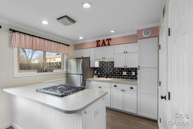 2464 Abbington Dr SE, Grand Rapids, MI 49506 - kitchen featuring freestanding refrigerator, a peninsula, light countertops, white cabinets, and a sink