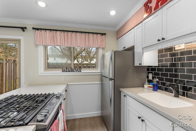 2464 Abbington Dr SE, Grand Rapids, MI 49506 - kitchen with tasteful backsplash, a sink, light countertops, white cabinets, and ornamental molding