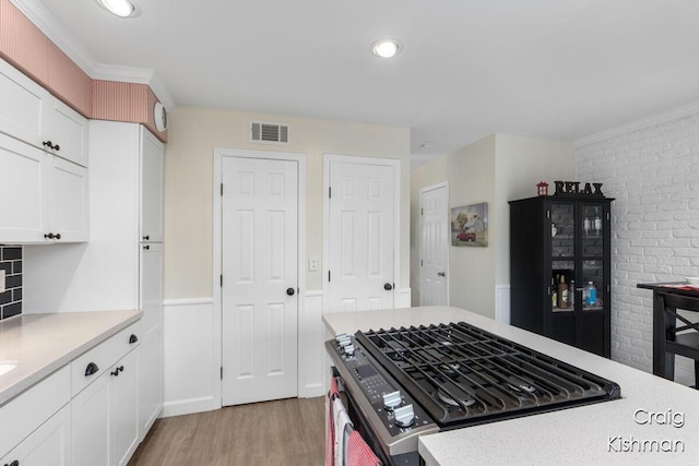 2464 Abbington Dr SE, Grand Rapids, MI 49506 - kitchen with stainless steel range with gas cooktop, light countertops, visible vents, and light wood-style floors