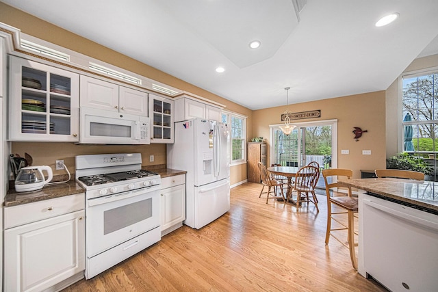 kitchen featuring white appliances, glass insert cabinets, light wood-style flooring, and a wealth of natural light