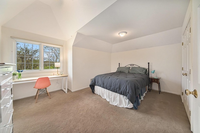 bedroom with light colored carpet, baseboards, and vaulted ceiling