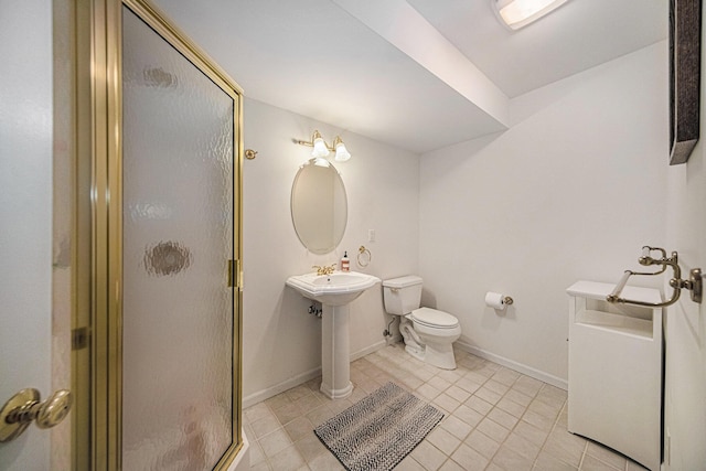 bathroom featuring tile patterned floors, baseboards, a stall shower, and toilet