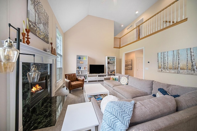 living room featuring high vaulted ceiling and a premium fireplace