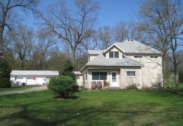 view of front of house featuring a shingled roof and a front lawn