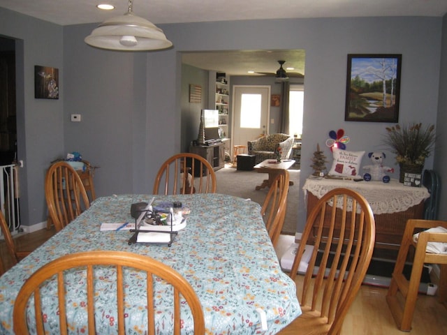 dining area featuring a ceiling fan and light wood-style floors