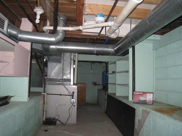 unfinished below grade area featuring concrete block wall and heating unit