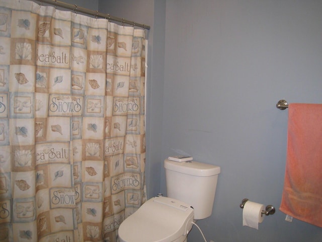 full bathroom featuring toilet and a shower with curtain