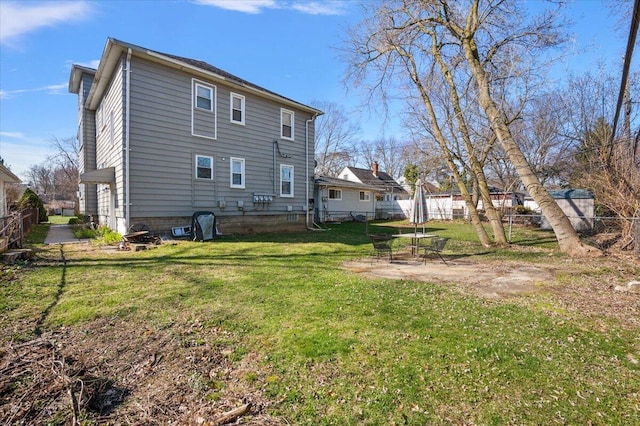rear view of house with a fenced backyard, a yard, and a patio area