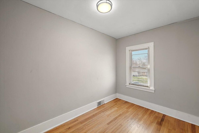 empty room with visible vents, baseboards, and light wood finished floors