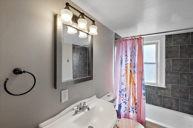 bathroom with toilet, a sink, and shower / bath combo