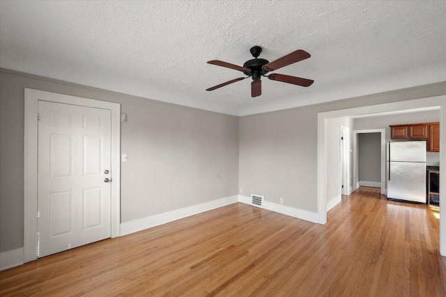 unfurnished room featuring visible vents, baseboards, ceiling fan, a textured ceiling, and light wood finished floors