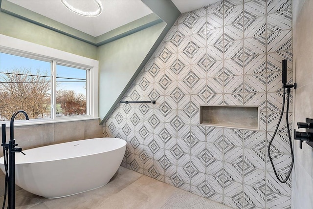 full bath featuring a freestanding bath, a tile shower, and tile walls