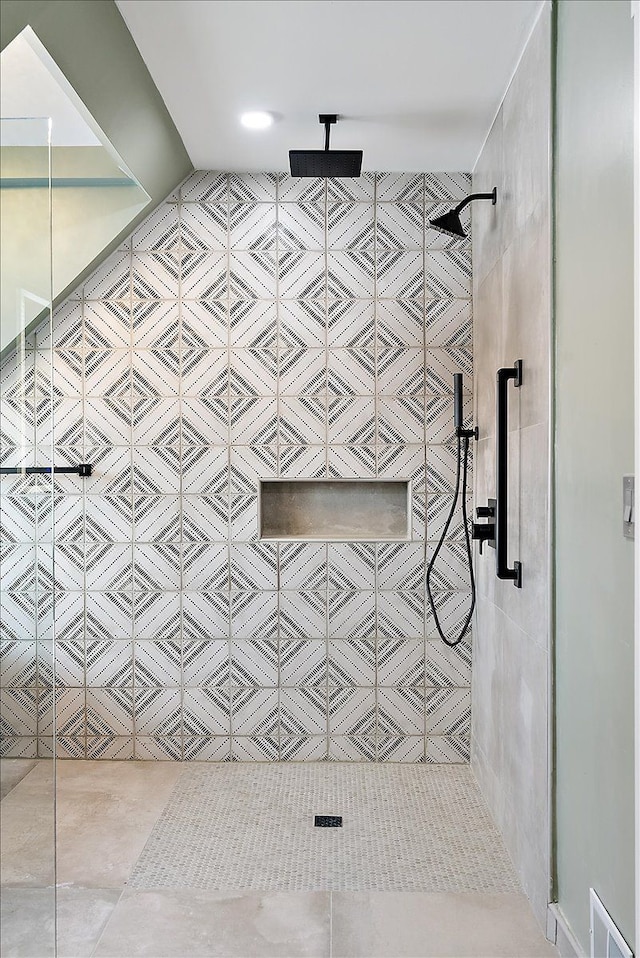 bathroom with tile patterned floors, a tile shower, and visible vents