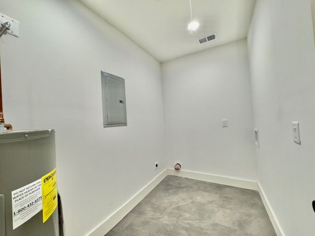 clothes washing area featuring water heater, baseboards, hookup for an electric dryer, visible vents, and electric panel