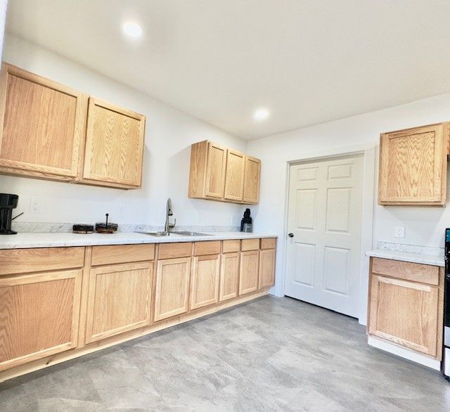 kitchen featuring a sink, light brown cabinetry, recessed lighting, and light countertops