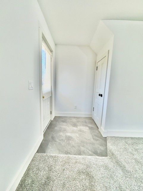 unfurnished room featuring baseboards and light colored carpet
