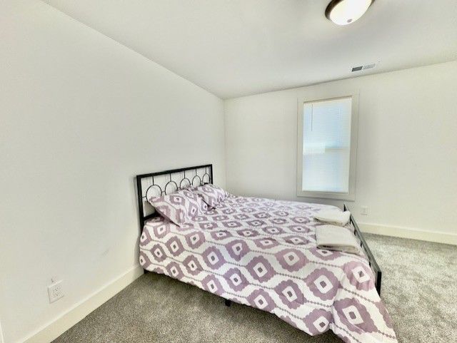 bedroom featuring carpet flooring, baseboards, and visible vents