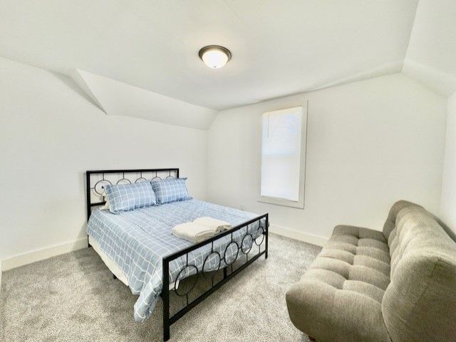 bedroom featuring baseboards, vaulted ceiling, and carpet flooring