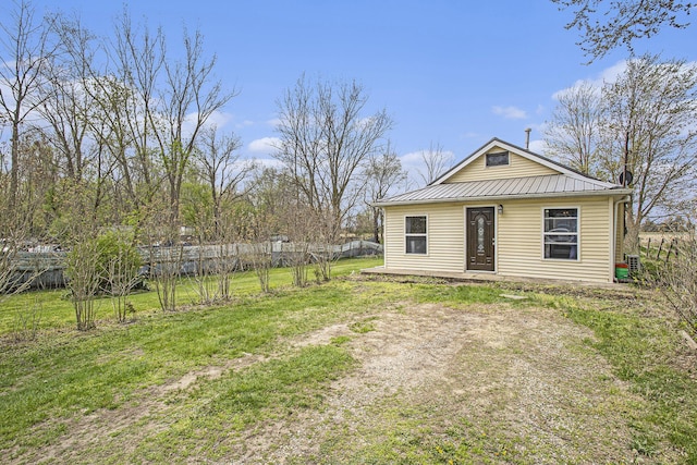 exterior space featuring a yard, a standing seam roof, metal roof, and a fenced backyard