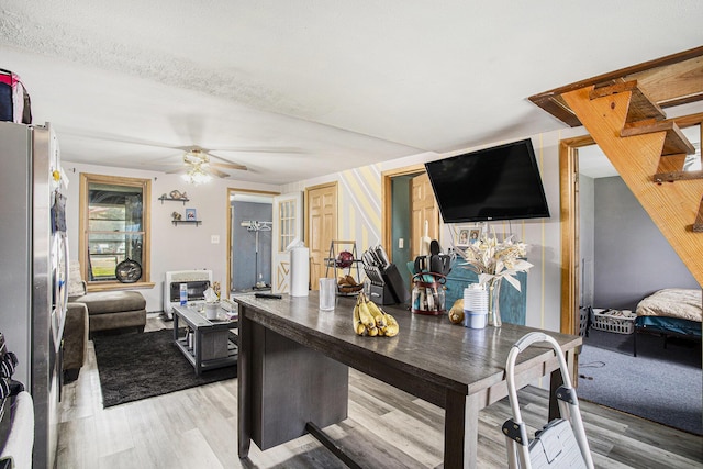 kitchen featuring freestanding refrigerator, a ceiling fan, light wood finished floors, and open floor plan