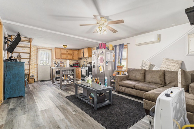 living room featuring ceiling fan, a wall mounted AC, a wealth of natural light, and light wood-style floors