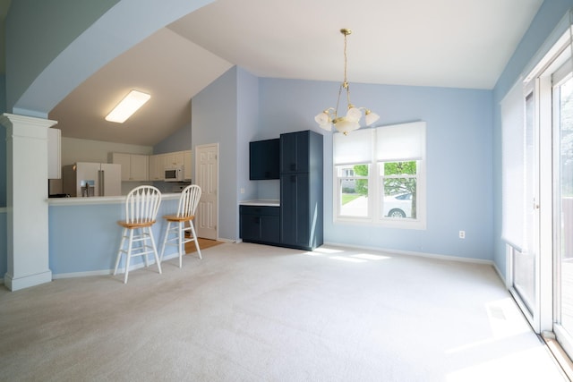 interior space featuring a breakfast bar, hanging light fixtures, a notable chandelier, light carpet, and white appliances