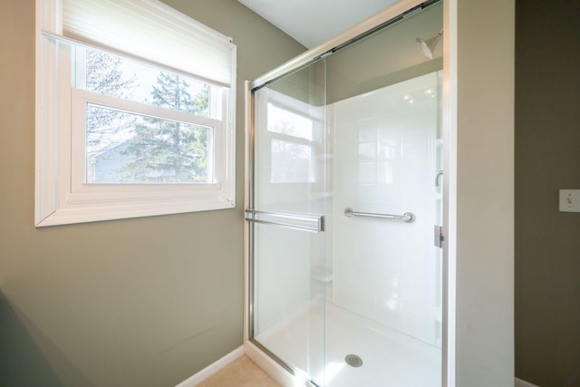 full bathroom featuring baseboards and a stall shower