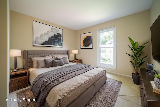 bedroom featuring baseboards and light carpet