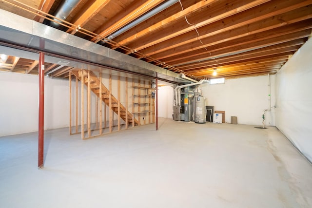 unfinished below grade area featuring stairway, heating unit, and water heater