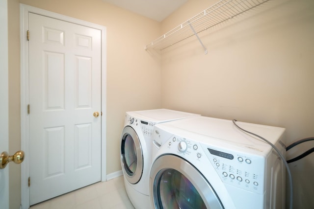 laundry room featuring separate washer and dryer, laundry area, and light tile patterned floors