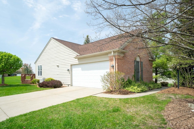 view of side of home featuring brick siding, a shingled roof, concrete driveway, an attached garage, and a yard
