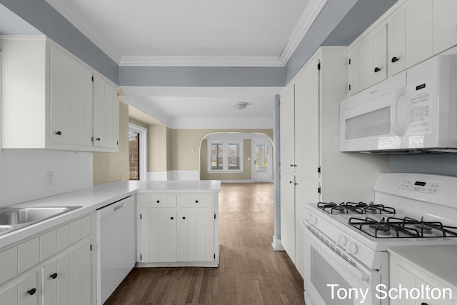 kitchen with white appliances, dark wood-style flooring, arched walkways, and white cabinetry