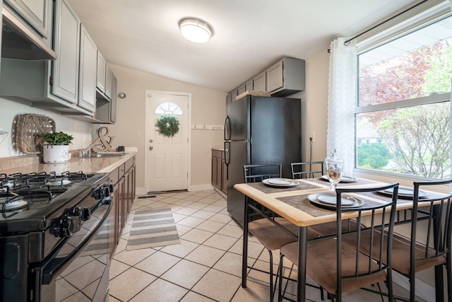 710 Robinwood St, Pontiac, MI 48340 - kitchen with ventilation hood, black appliances, lofted ceiling, plenty of natural light, and light countertops