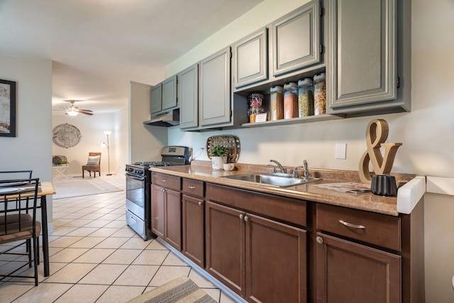 710 Robinwood St, Pontiac, MI 48340 - kitchen with stainless steel range with gas stovetop, a sink, under cabinet range hood, ceiling fan, and light tile patterned flooring
