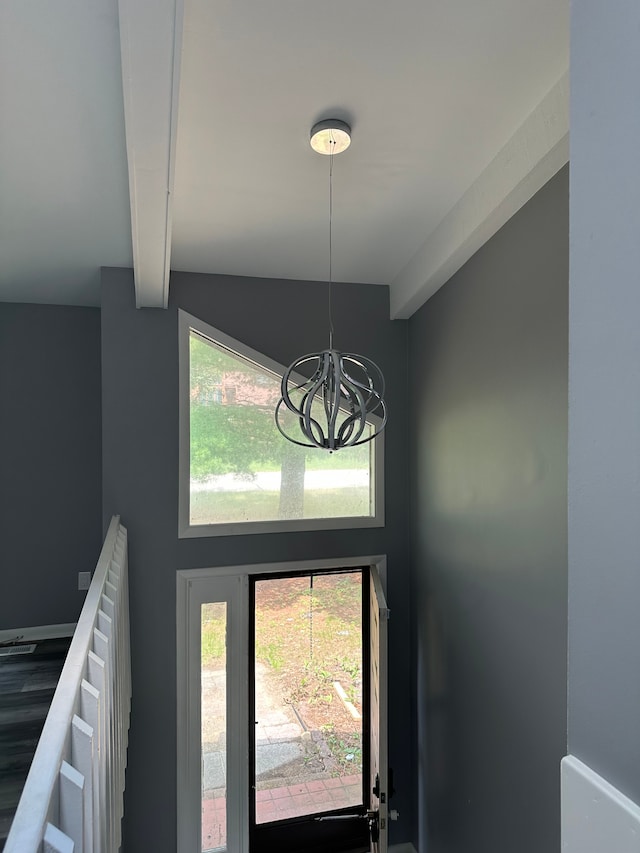 details featuring an inviting chandelier and beam ceiling