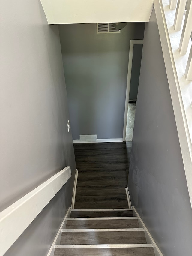 stairs featuring baseboards, visible vents, and wood finished floors