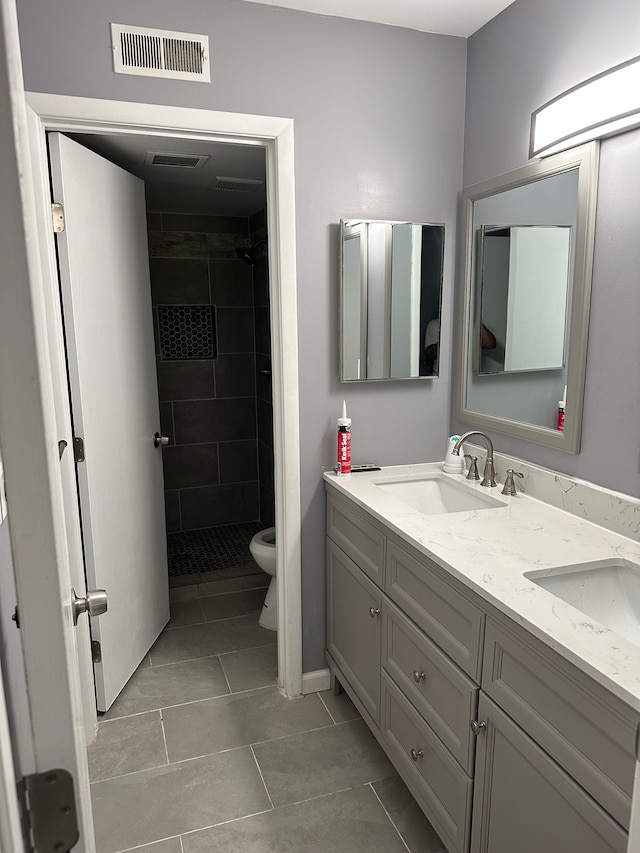 full bath with toilet, visible vents, a sink, and double vanity