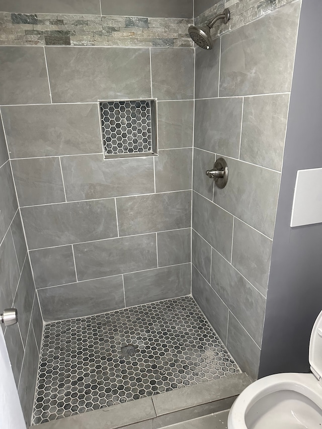 full bath featuring toilet and a stall shower
