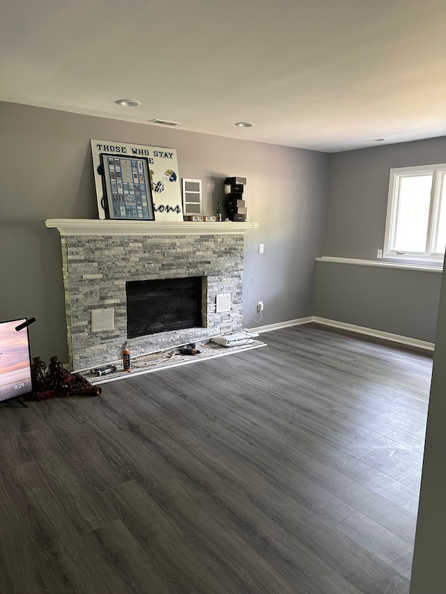 unfurnished living room featuring a fireplace, wood finished floors, and baseboards