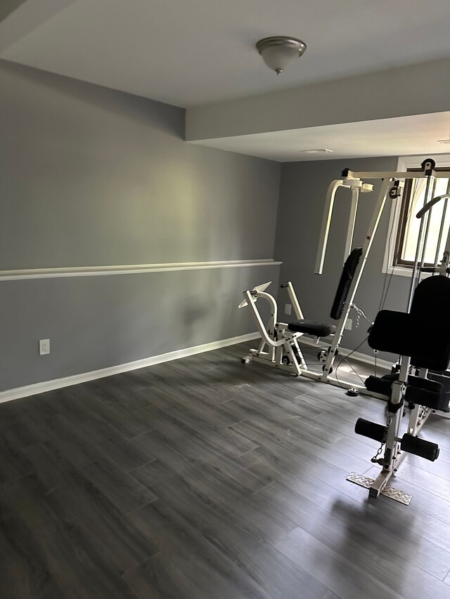 workout room featuring baseboards and wood finished floors