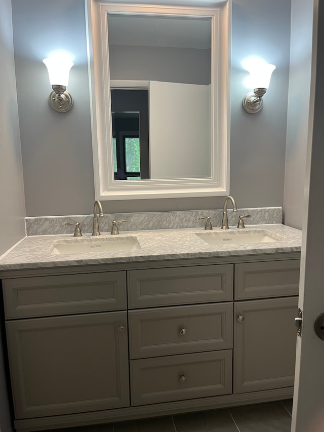 bathroom with double vanity, tile patterned flooring, and a sink