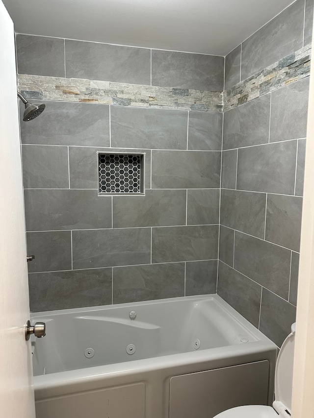 bathroom with toilet and a combined bath / shower with jetted tub