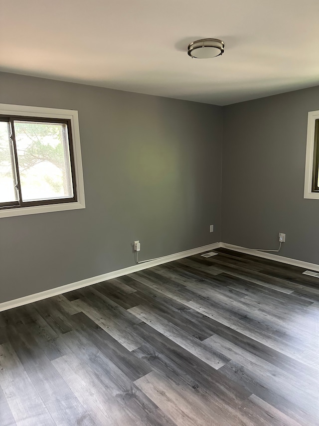unfurnished room featuring dark wood-style floors and baseboards